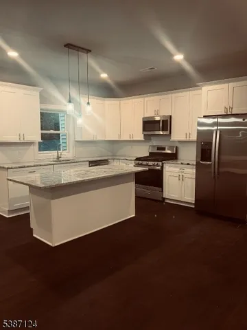 a kitchen with stainless steel appliances granite countertop a stove a sink and a refrigerator