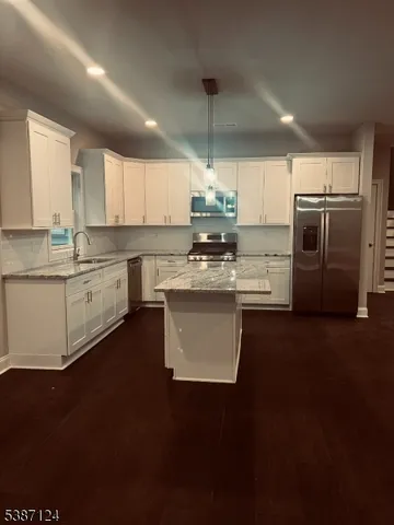 a kitchen with stainless steel appliances a sink a stove a refrigerator cabinets and a counter top space