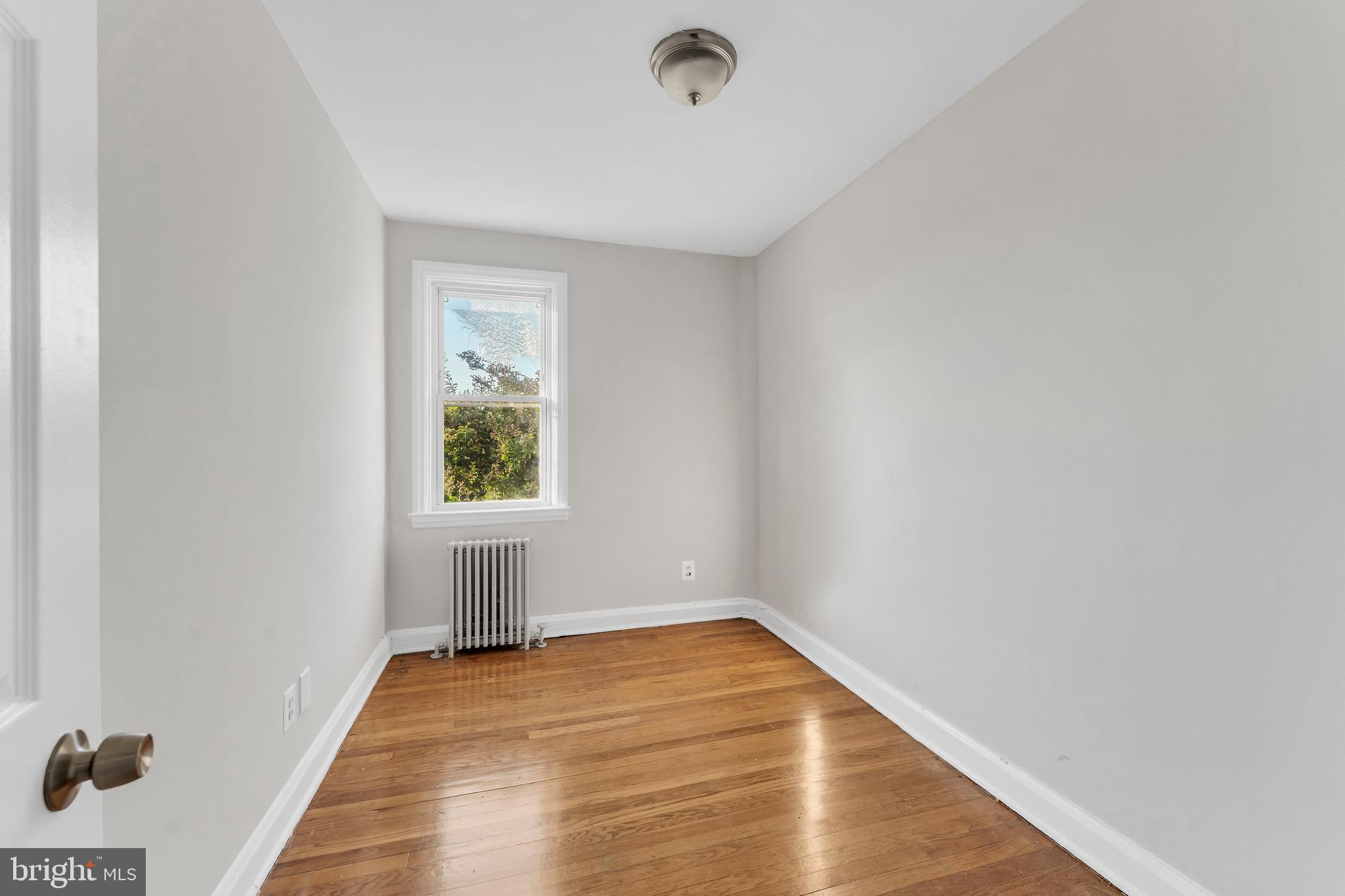 3937 Flowerton Road Baltimore, MD 21229 - Photo 12 of 28 a view of an empty room with wooden floor and a window