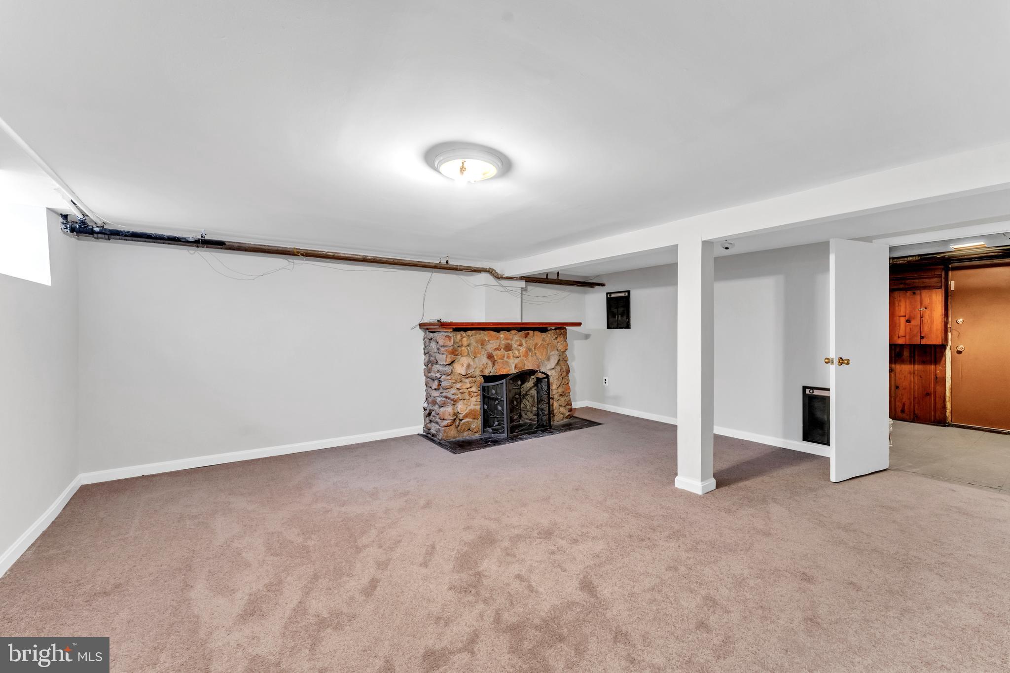3937 Flowerton Road Baltimore, MD 21229 - Photo 18 of 28 an empty room with a fireplace and chandelier