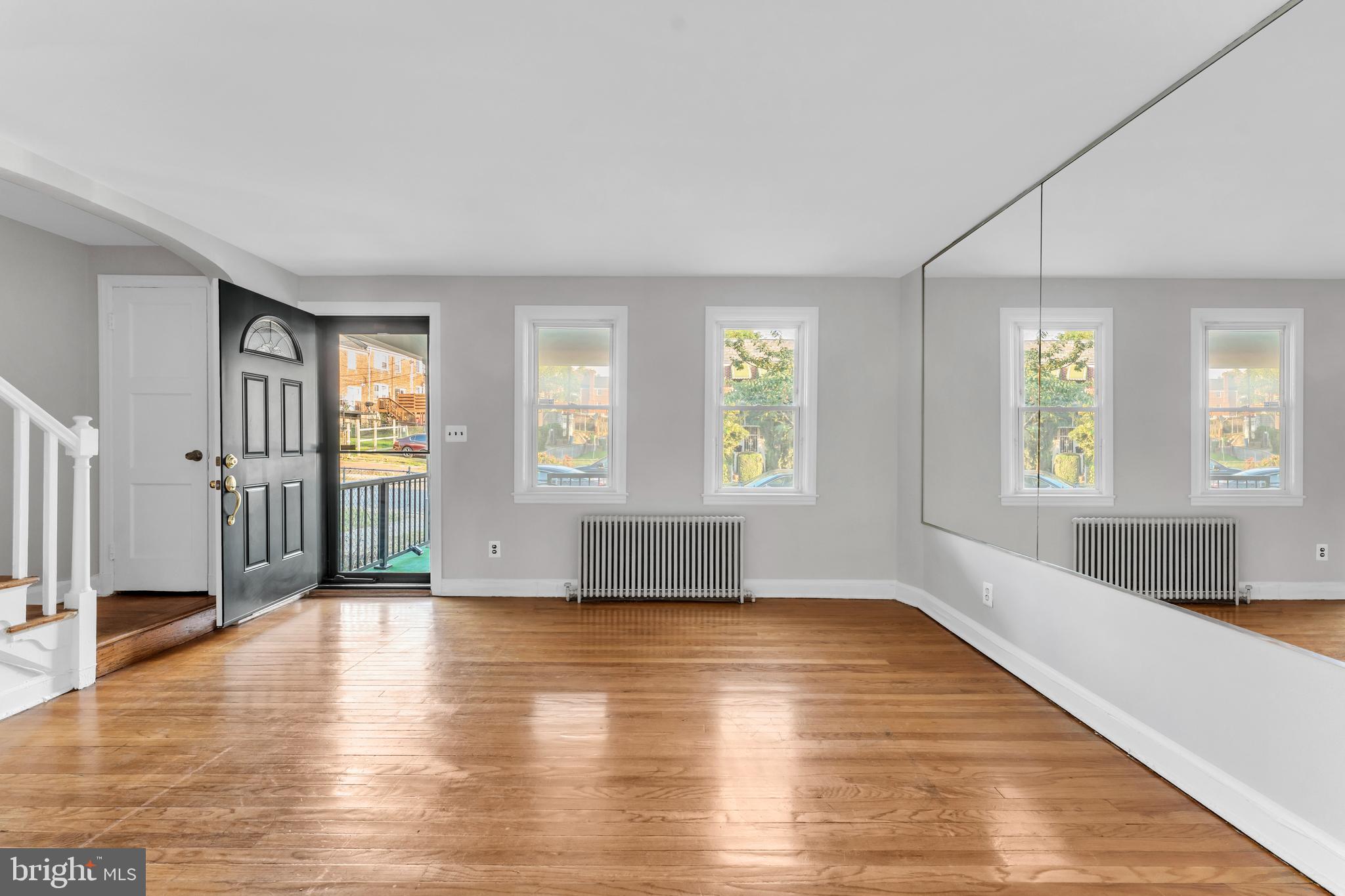 3937 Flowerton Road Baltimore, MD 21229 - Photo 3 of 28 an empty room with wooden floor and windows