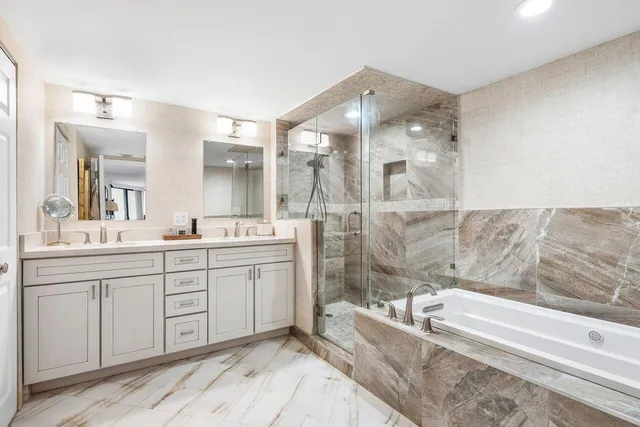 a spacious bathroom with a tub sink shower and mirror