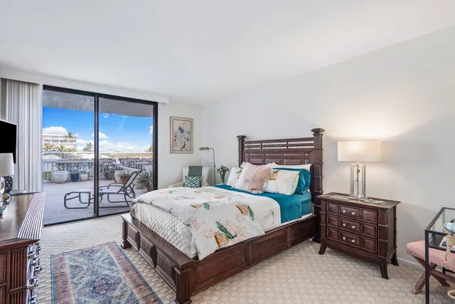 a bedroom with a bed a table and flat screen tv