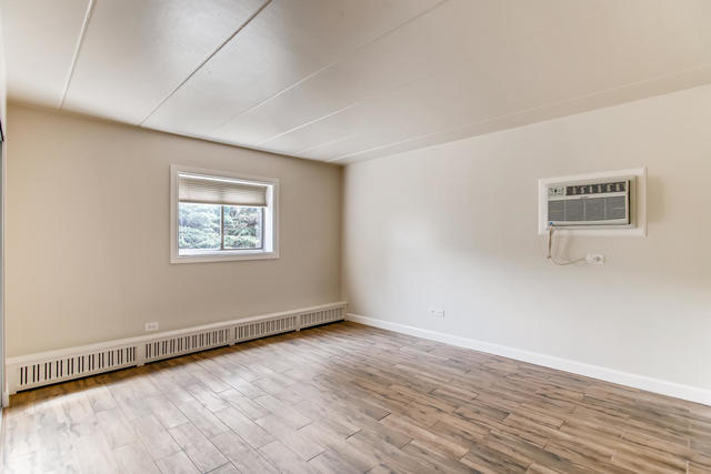 208 East Bailey Road, Unit A Naperville, IL 60565 - Photo 14 of 20 a view of an empty room with wooden floor and a window