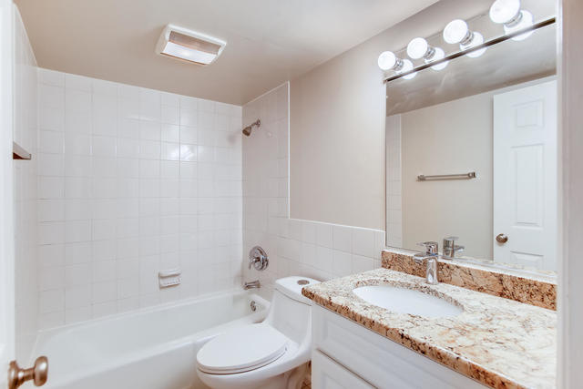 208 East Bailey Road, Unit A Naperville, IL 60565 - Photo 15 of 20 a bathroom with a granite countertop sink a toilet a mirror and bathtub
