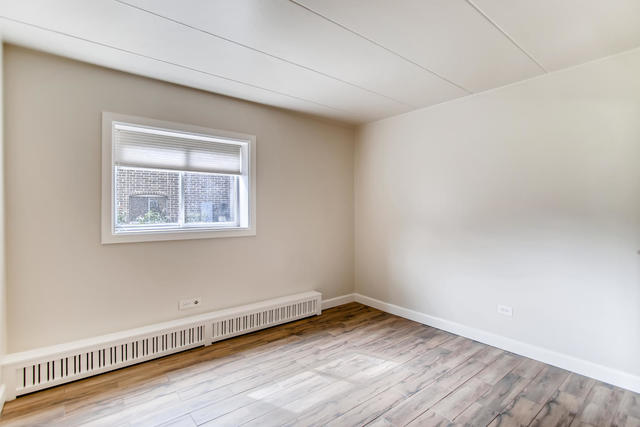 208 East Bailey Road, Unit A Naperville, IL 60565 - Photo 16 of 20 a view of an empty room with wooden floor and a window