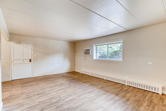 208 East Bailey Road, Unit A Naperville, IL 60565 - Photo 4 of 20 an empty room with wooden floor and windows