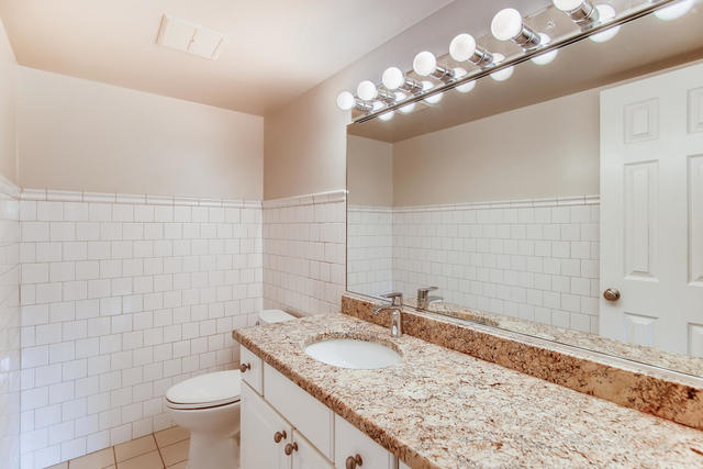 208 East Bailey Road, Unit A Naperville, IL 60565 - Photo 10 of 20 a bathroom with a granite countertop sink a toilet and a mirror