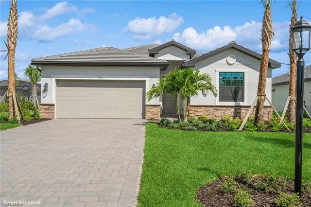 a view of a house with brick walls and a yard with plants