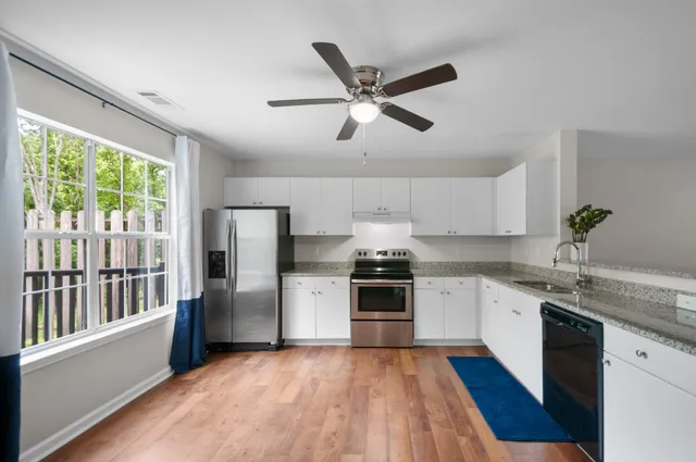 a kitchen with granite countertop stainless steel appliances a stove sink and refrigerator