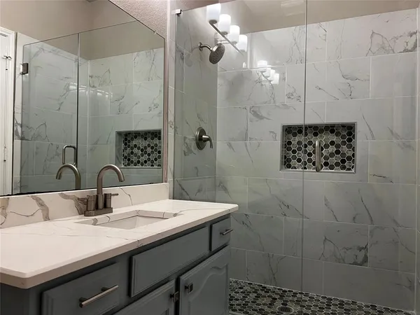 a bathroom with a sink a mirror and shower