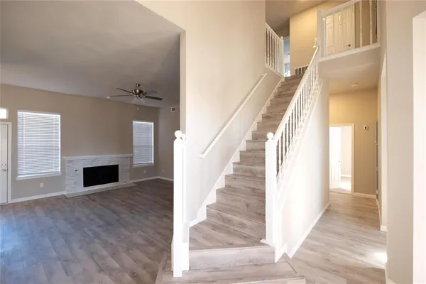 a view of a livingroom with wooden floor and staircase