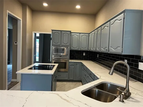 a kitchen that has a sink and a stove in it