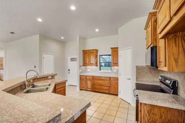 a kitchen with stainless steel appliances granite countertop a sink a stove and a refrigerator