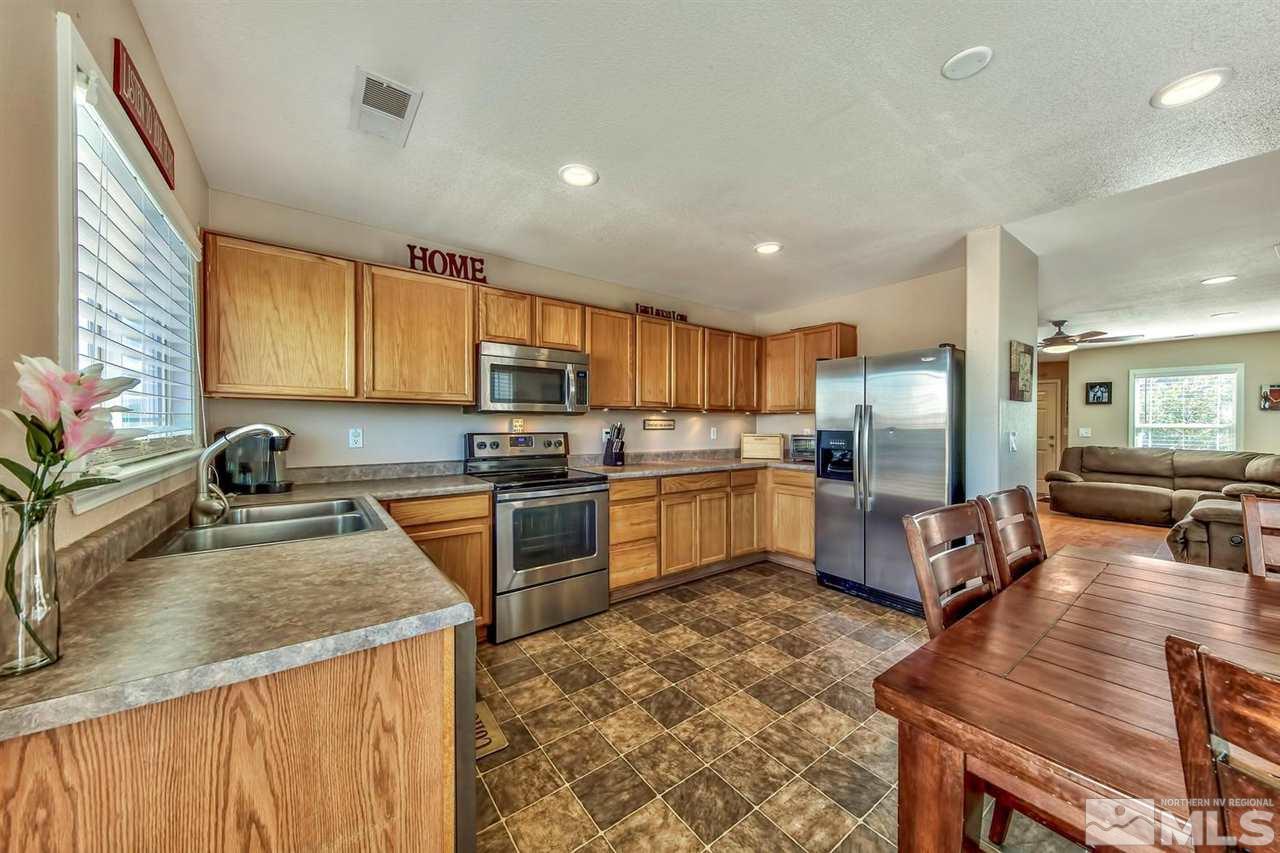 7733 Tulear Street Reno, NV 89506 - Photo 7 of 16 a kitchen with granite countertop a counter top space a sink stainless steel appliances and cabinets