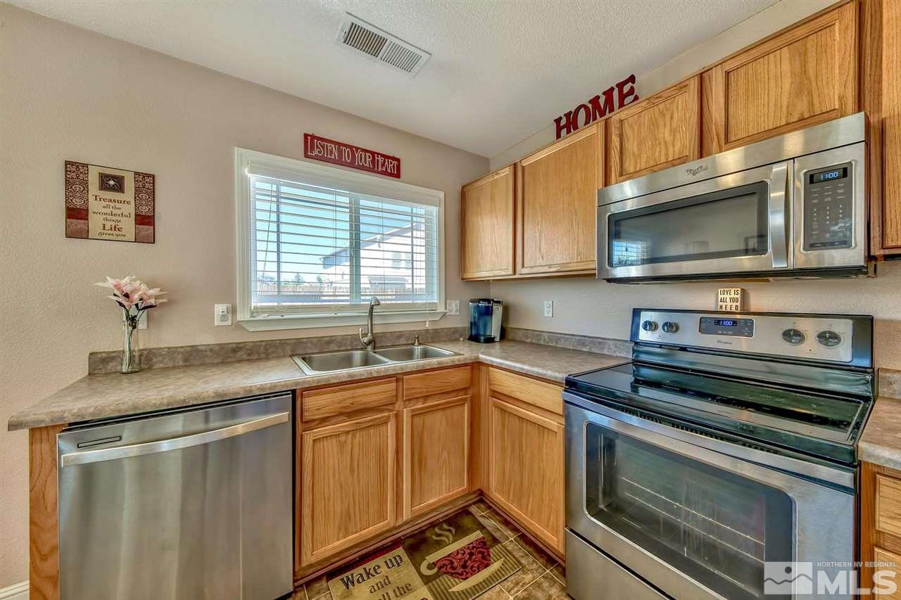 7733 Tulear Street Reno, NV 89506 - Photo 8 of 16 a kitchen with stainless steel appliances a stove sink microwave and cabinets