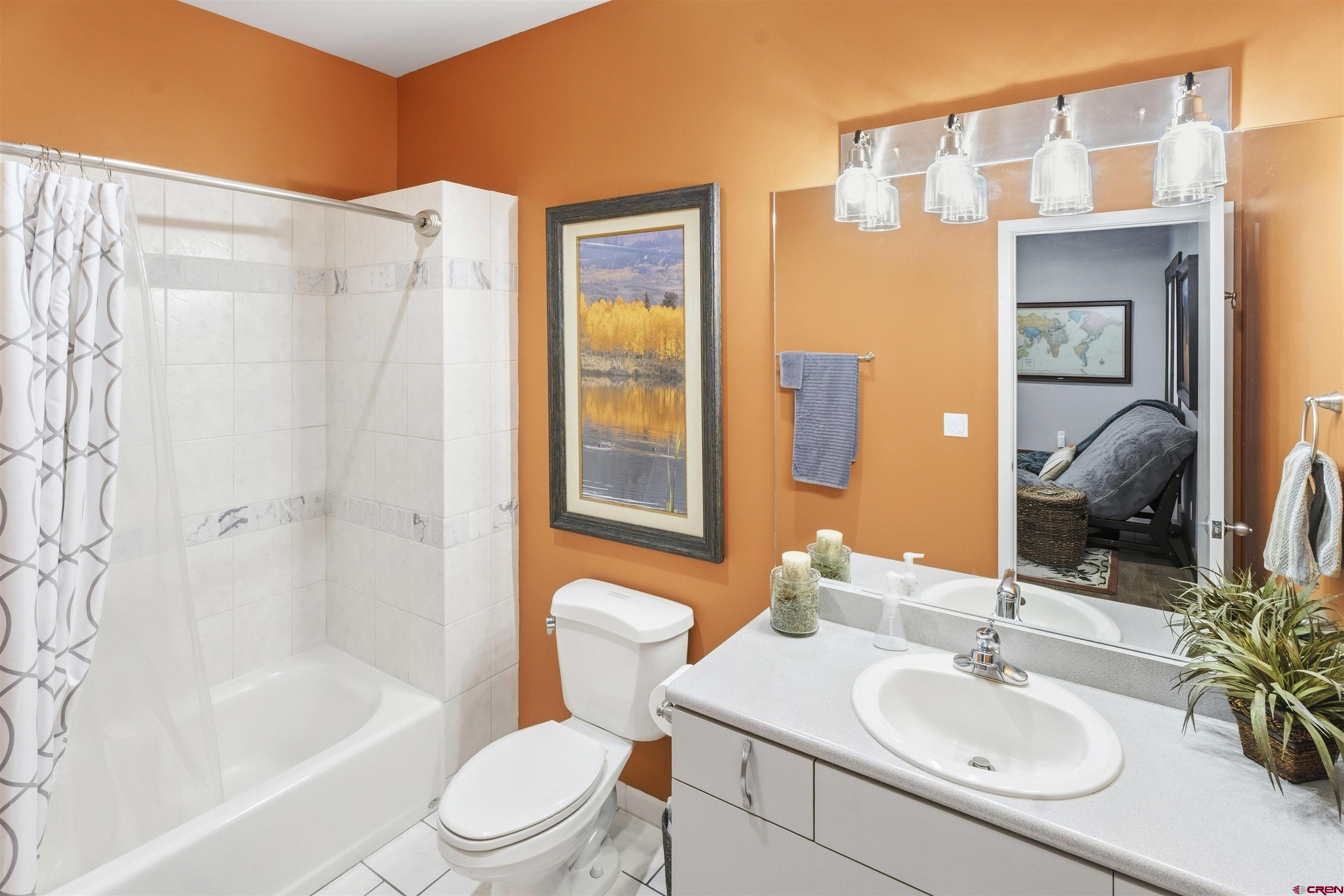 684 Falcon Way Montrose, CO 81403 - Photo 22 of 43 a bathroom with a sink toilet a mirror and shower