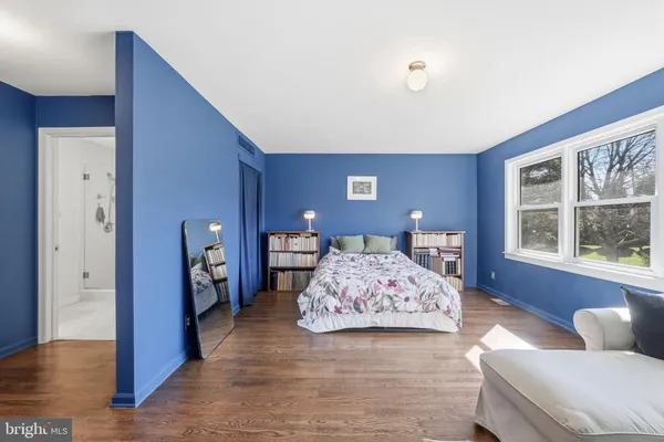 a bedroom with a bed and a couch with window