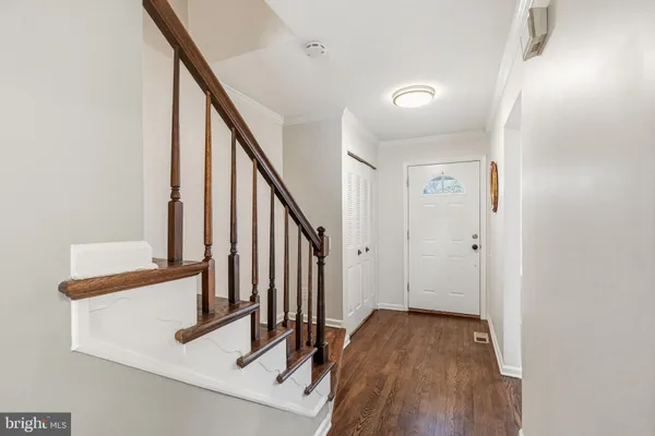 a view of a hallway with wooden floor and entryway