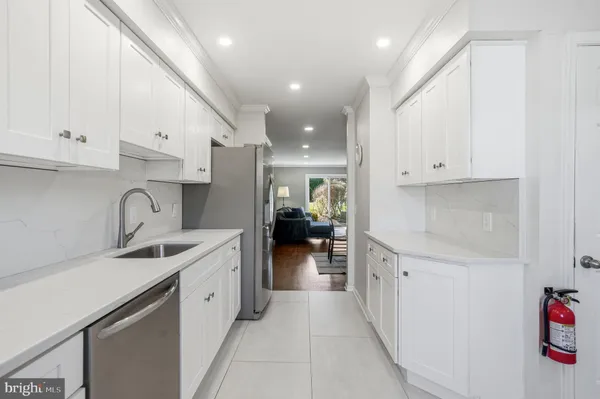 a kitchen with white cabinets and stainless steel appliances