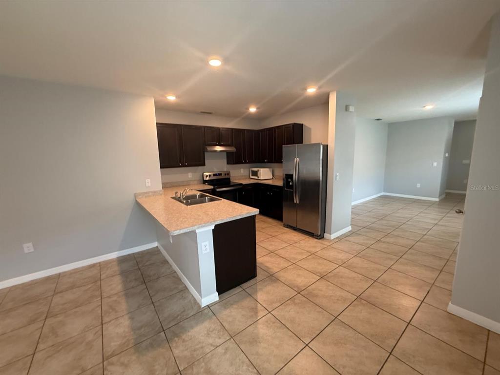 754 Chinoy Road Davenport, FL 33837 - Photo 14 of 26 a kitchen with stainless steel appliances a refrigerator sink and microwave