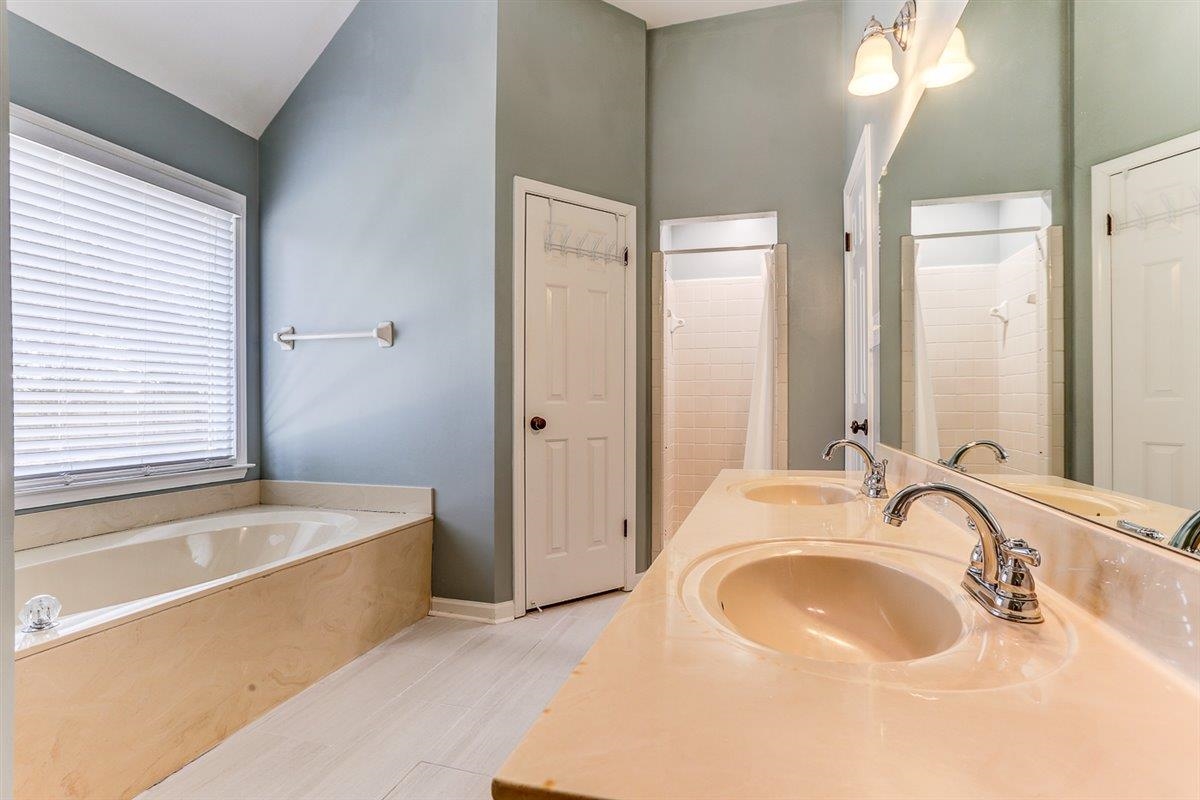 665 Lancelot Lane Collierville, TN 38017 - Photo 16 of 26 a bathroom with a tub sink and mirror