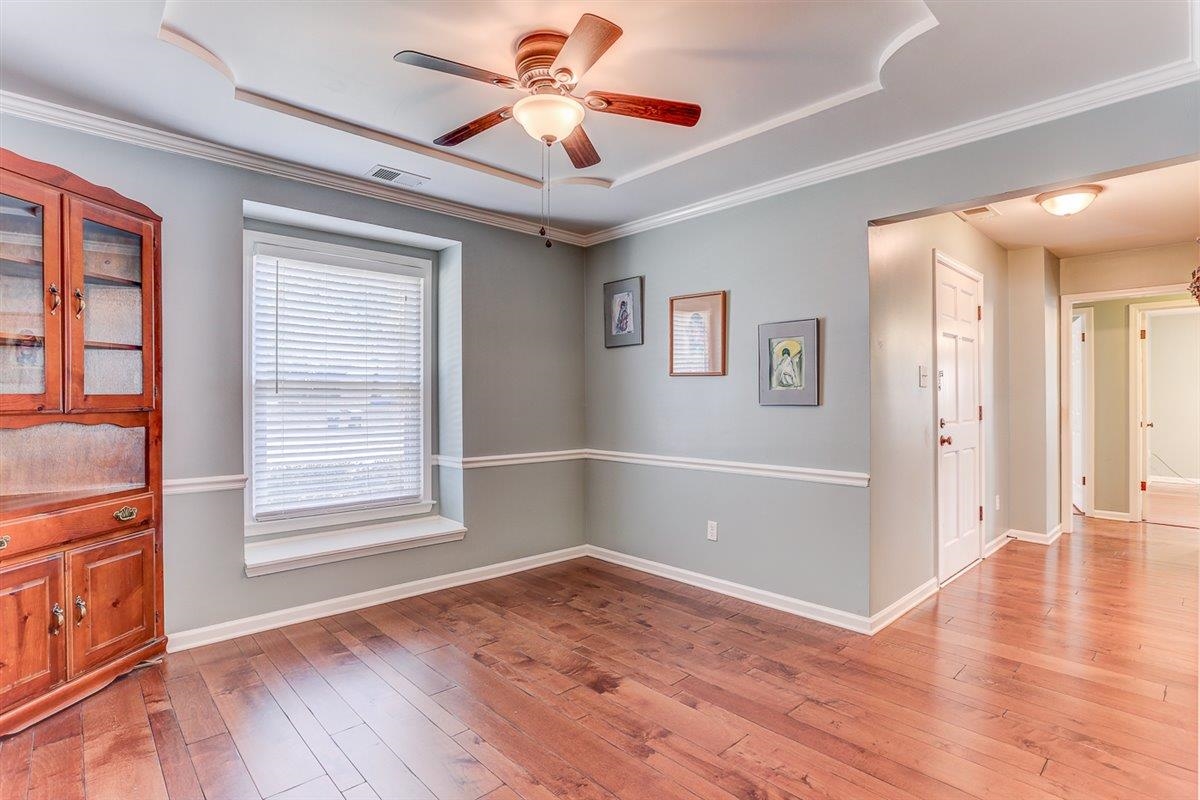 665 Lancelot Lane Collierville, TN 38017 - Photo 5 of 26 an empty room with wooden floor chandelier fan and windows