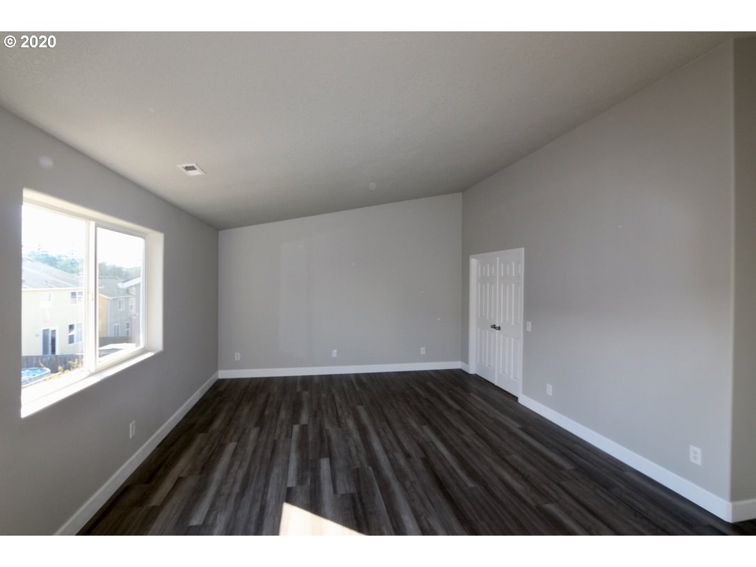 1986 Southwest 33rd Street Gresham, OR 97080 - Photo 20 of 32 a view of an empty room with wooden floor and a window