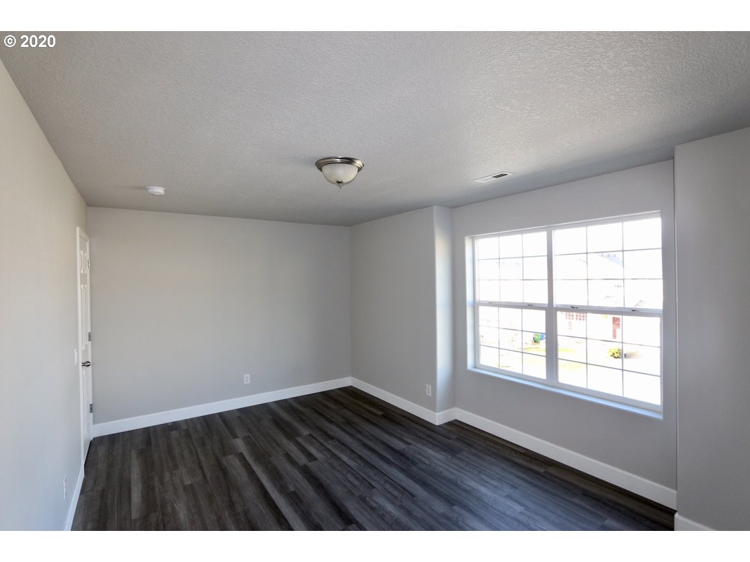 1986 Southwest 33rd Street Gresham, OR 97080 - Photo 27 of 32 a view of an empty room with wooden floor and a window