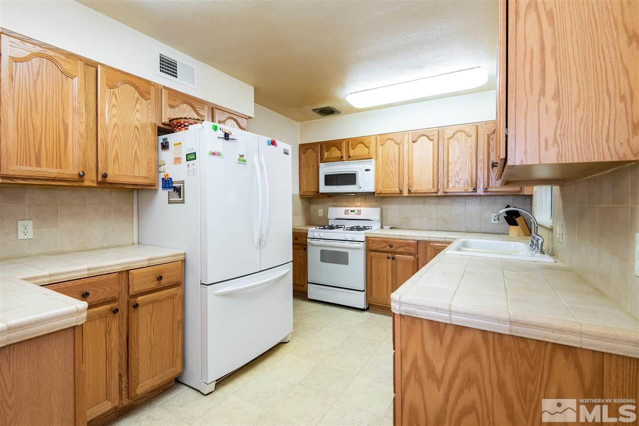 1555 Auburn Way Reno, NV 89502 - Photo 5 of 14 a kitchen with a refrigerator a stove a sink dishwasher and cabinets with wooden floor