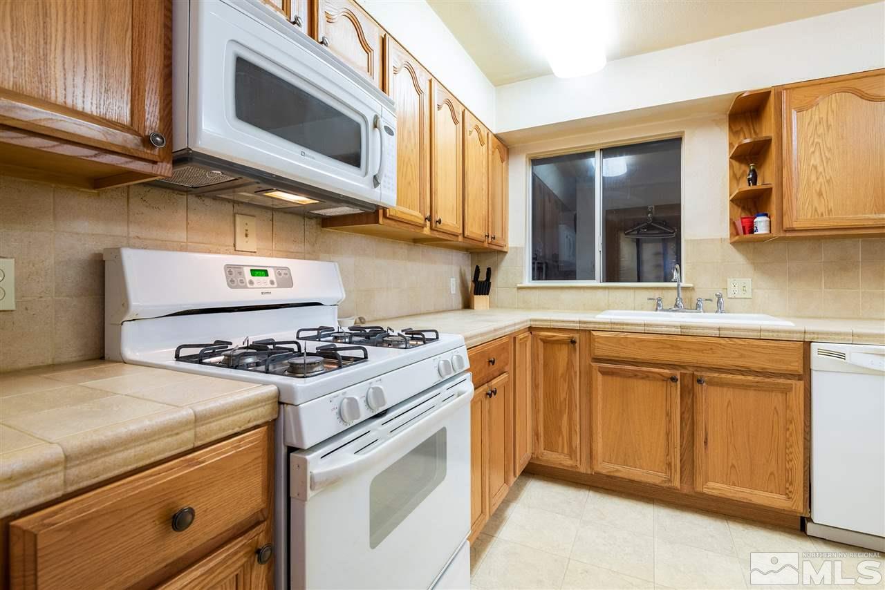 1555 Auburn Way Reno, NV 89502 - Photo 6 of 14 a kitchen with stainless steel appliances granite countertop a stove and a microwave