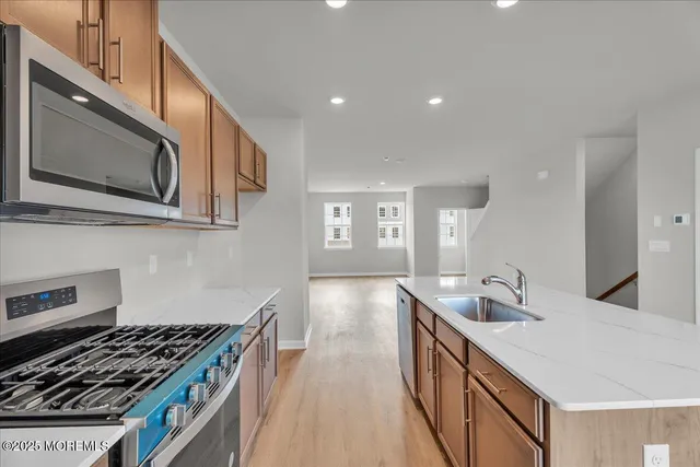 a kitchen with stainless steel appliances granite countertop a sink stove and microwave