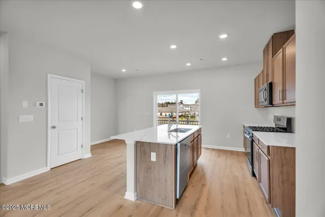 a kitchen with stainless steel appliances granite countertop a sink stove and wooden floor