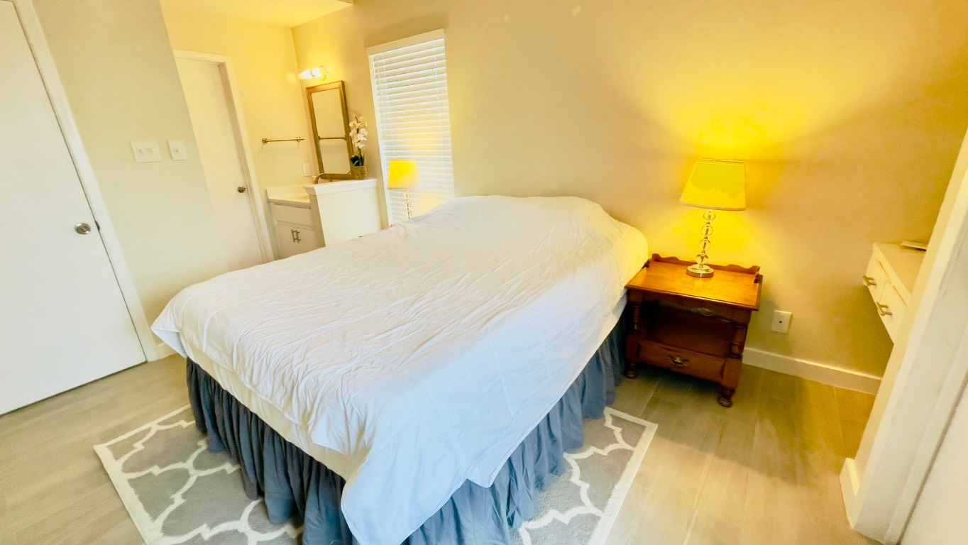 2902 Cole Street, Unit 311 Austin, TX 78705 - Photo 11 of 16 Bedroom with light wood-style flooring and ensuite bath