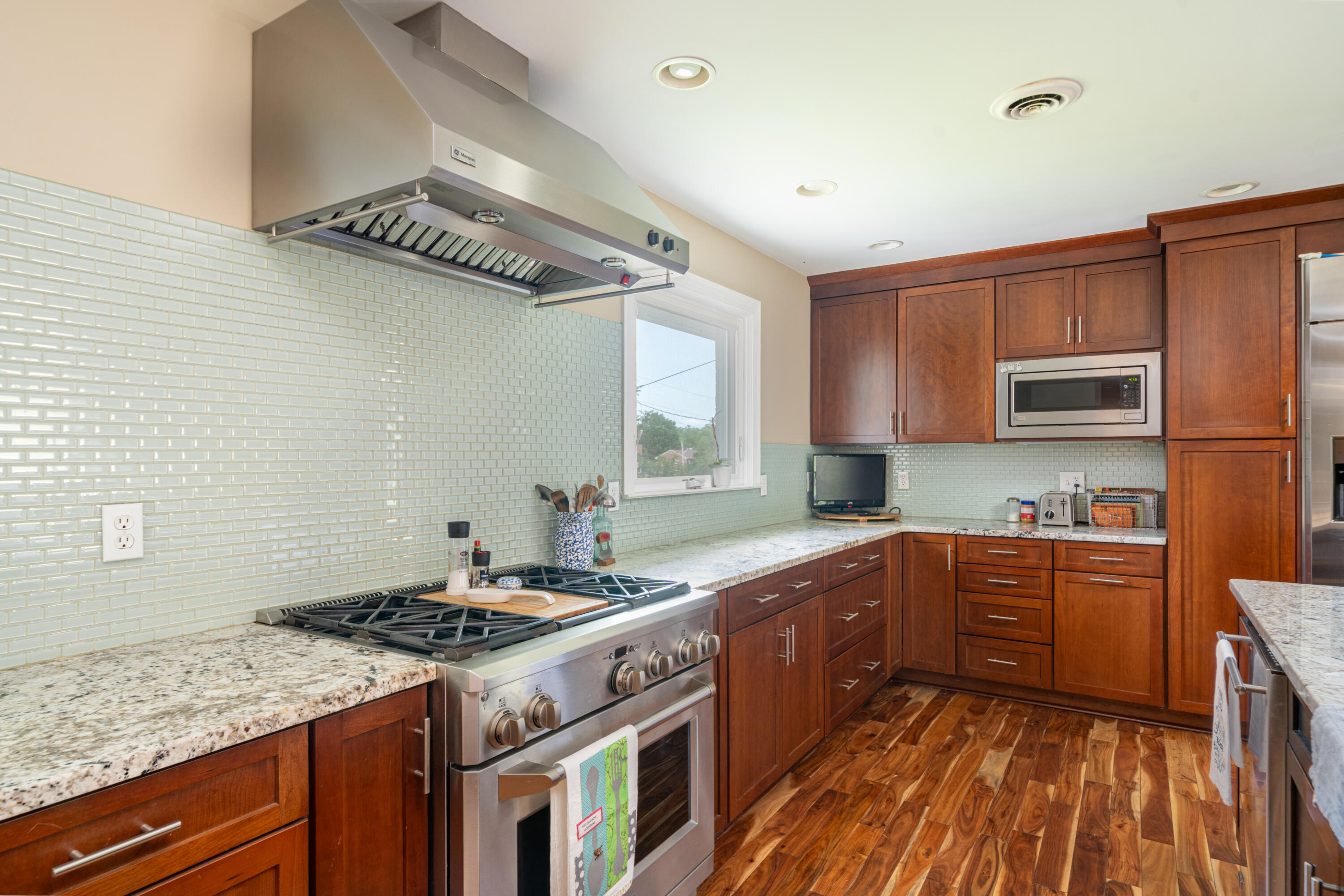 1719 Blair Road Southwest Roanoke, VA 24015 - Photo 9 of 40 a kitchen with stainless steel appliances granite countertop a stove a sink dishwasher and a microwave oven with wooden floor