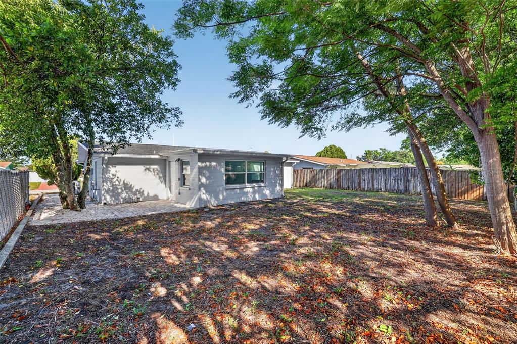 10914 Leeds Road Port Richey, FL 34668 - Photo 19 of 24 a view of a house with backyard and a tree