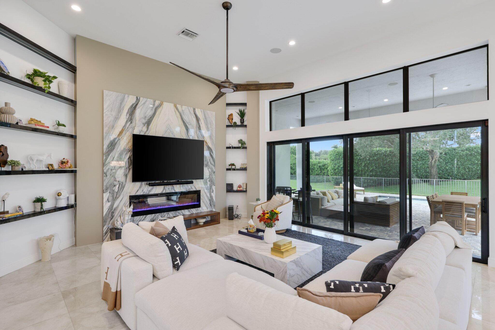 2751 Northwest 70th Boulevard Boca Raton, FL 33496 - Photo 17 of 76 a living room with furniture a flat screen tv and a large window