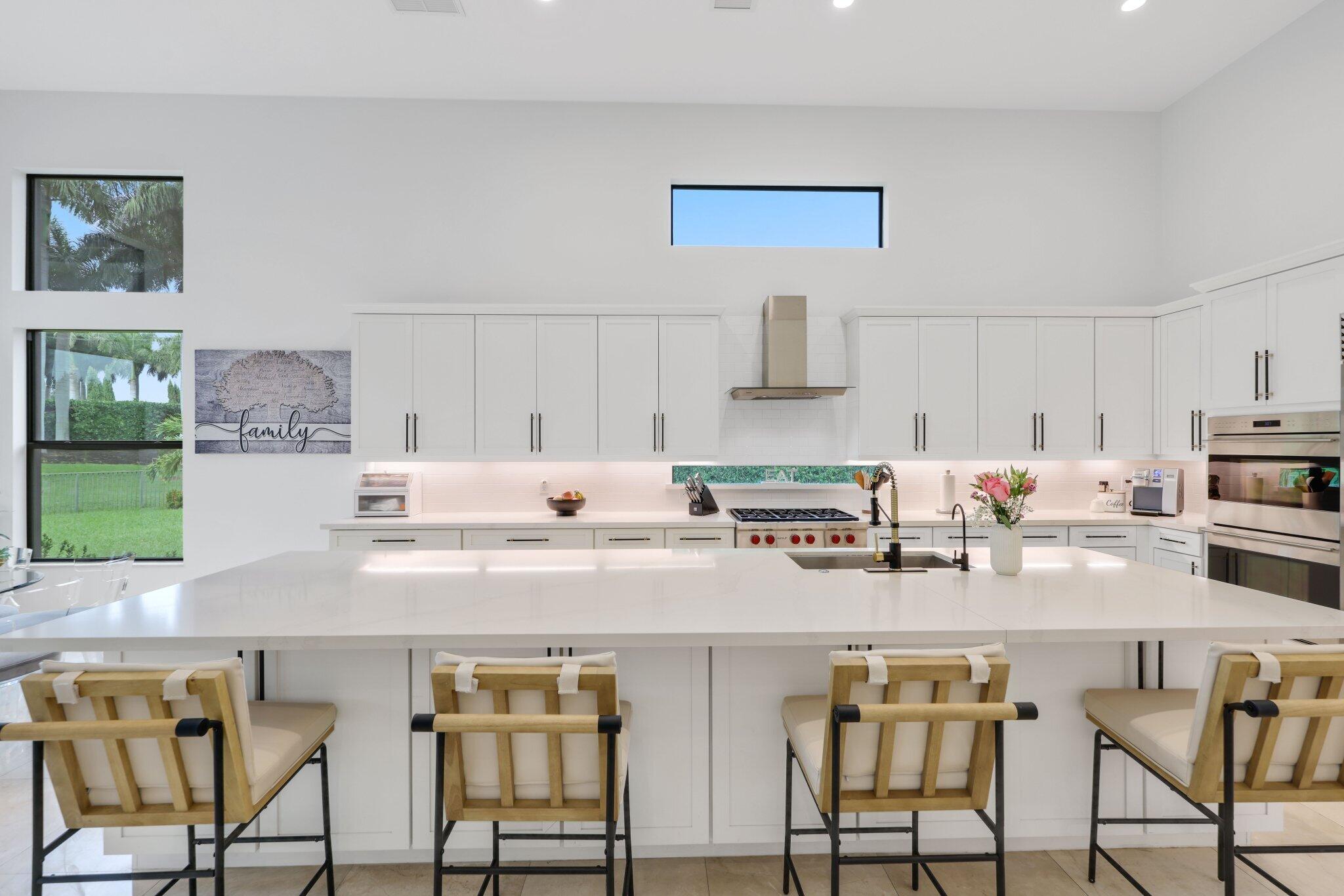 2751 Northwest 70th Boulevard Boca Raton, FL 33496 - Photo 22 of 76 a kitchen with stainless steel appliances a table chairs and a refrigerator