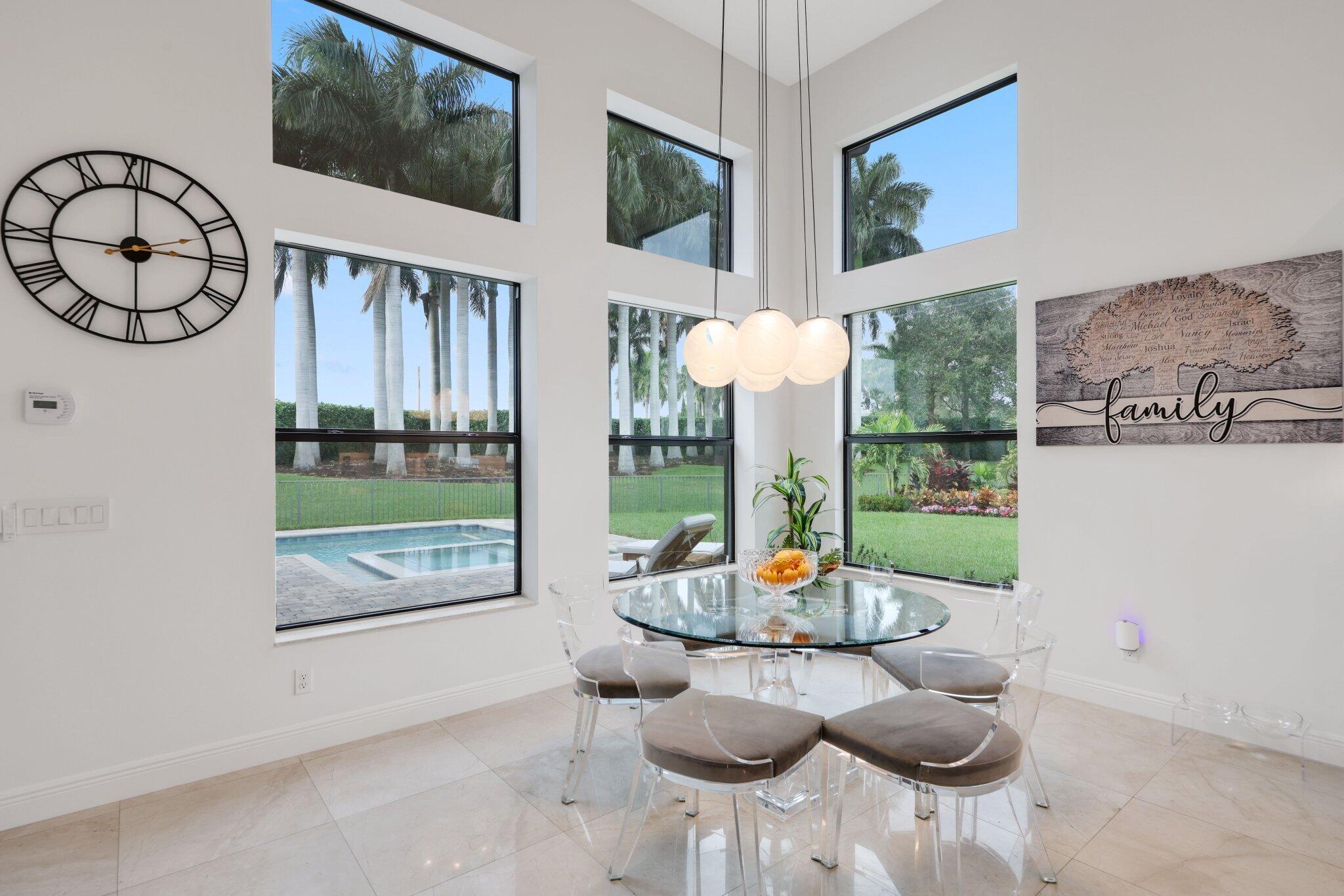2751 Northwest 70th Boulevard Boca Raton, FL 33496 - Photo 26 of 76 a view of a dining room with furniture a chandelier and wooden floor