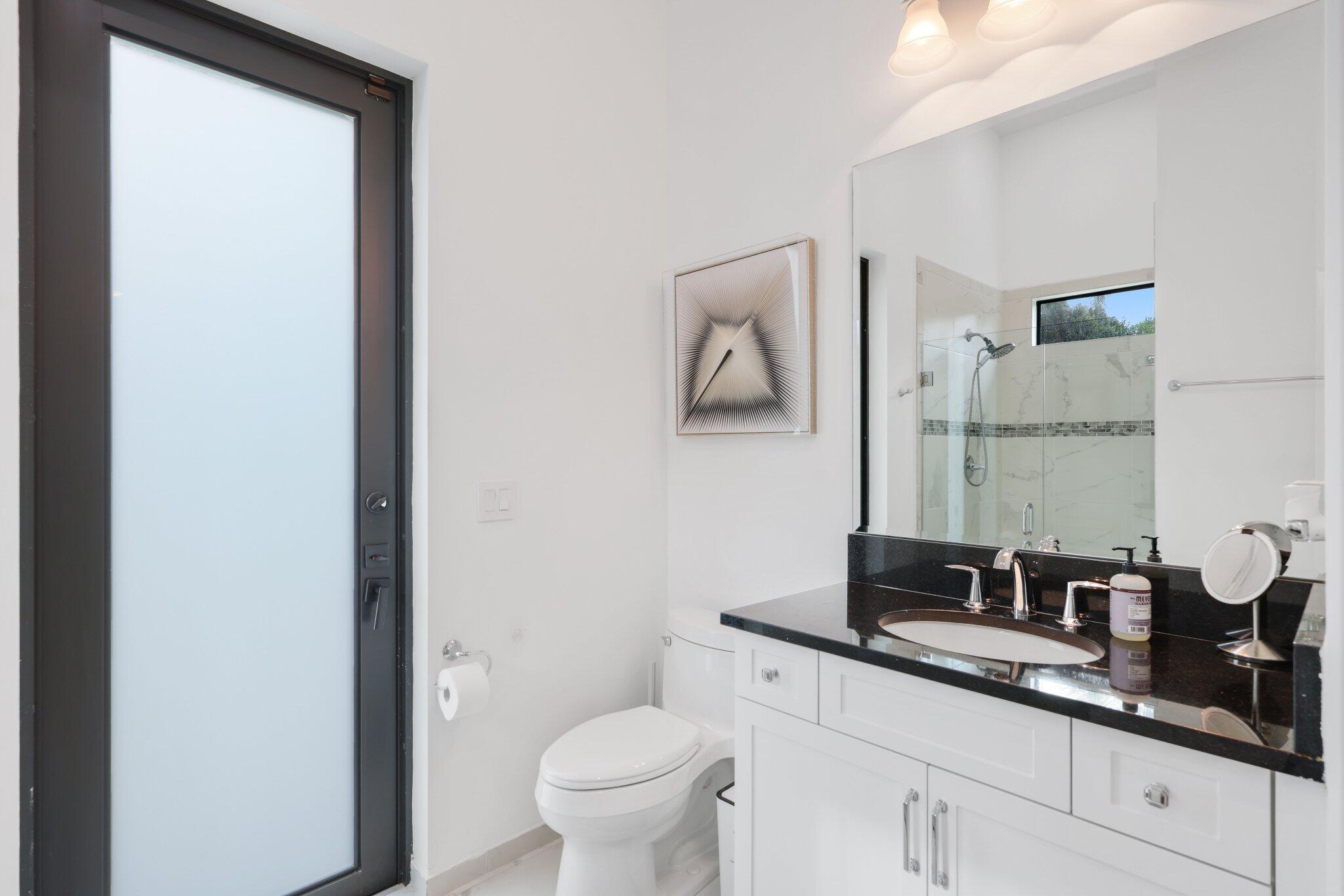 2751 Northwest 70th Boulevard Boca Raton, FL 33496 - Photo 41 of 76 a bathroom with a granite countertop sink a toilet and mirror