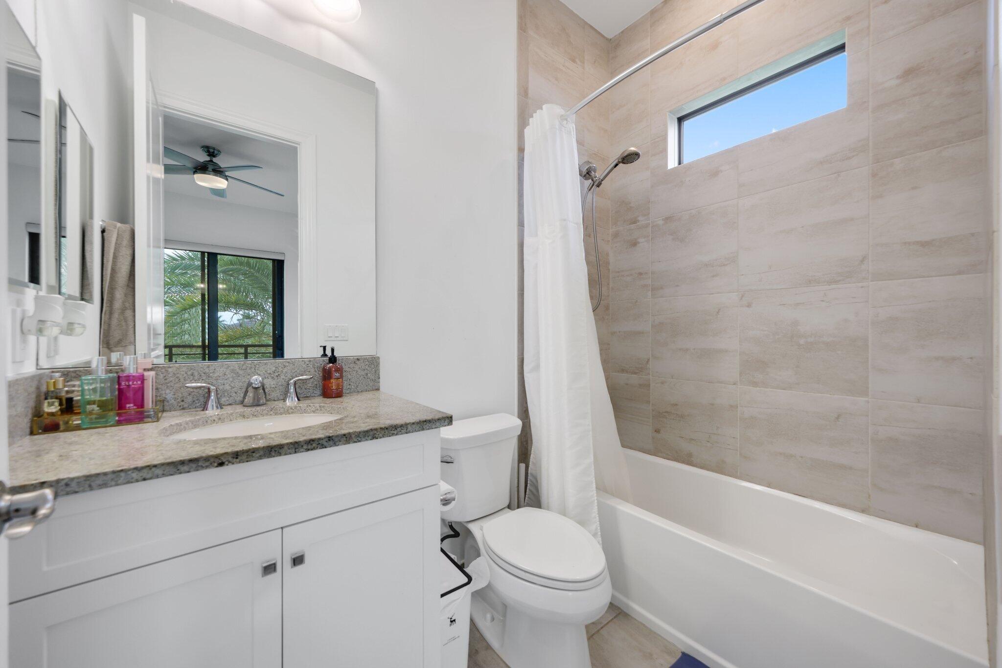 2751 Northwest 70th Boulevard Boca Raton, FL 33496 - Photo 46 of 76 a bathroom with a granite countertop sink toilet mirror and bathtub