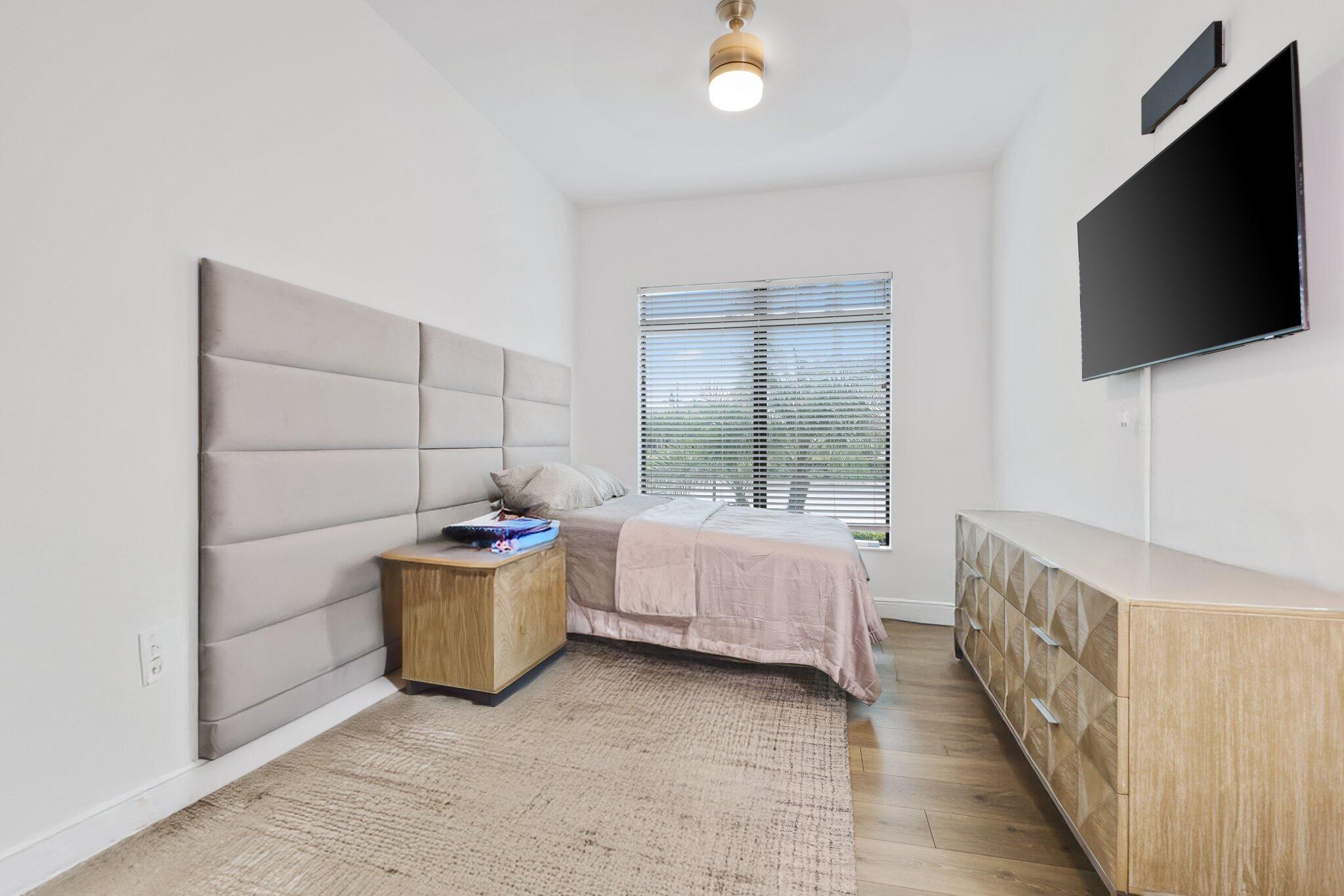 2751 Northwest 70th Boulevard Boca Raton, FL 33496 - Photo 53 of 76 a room with a bed and flat screen tv