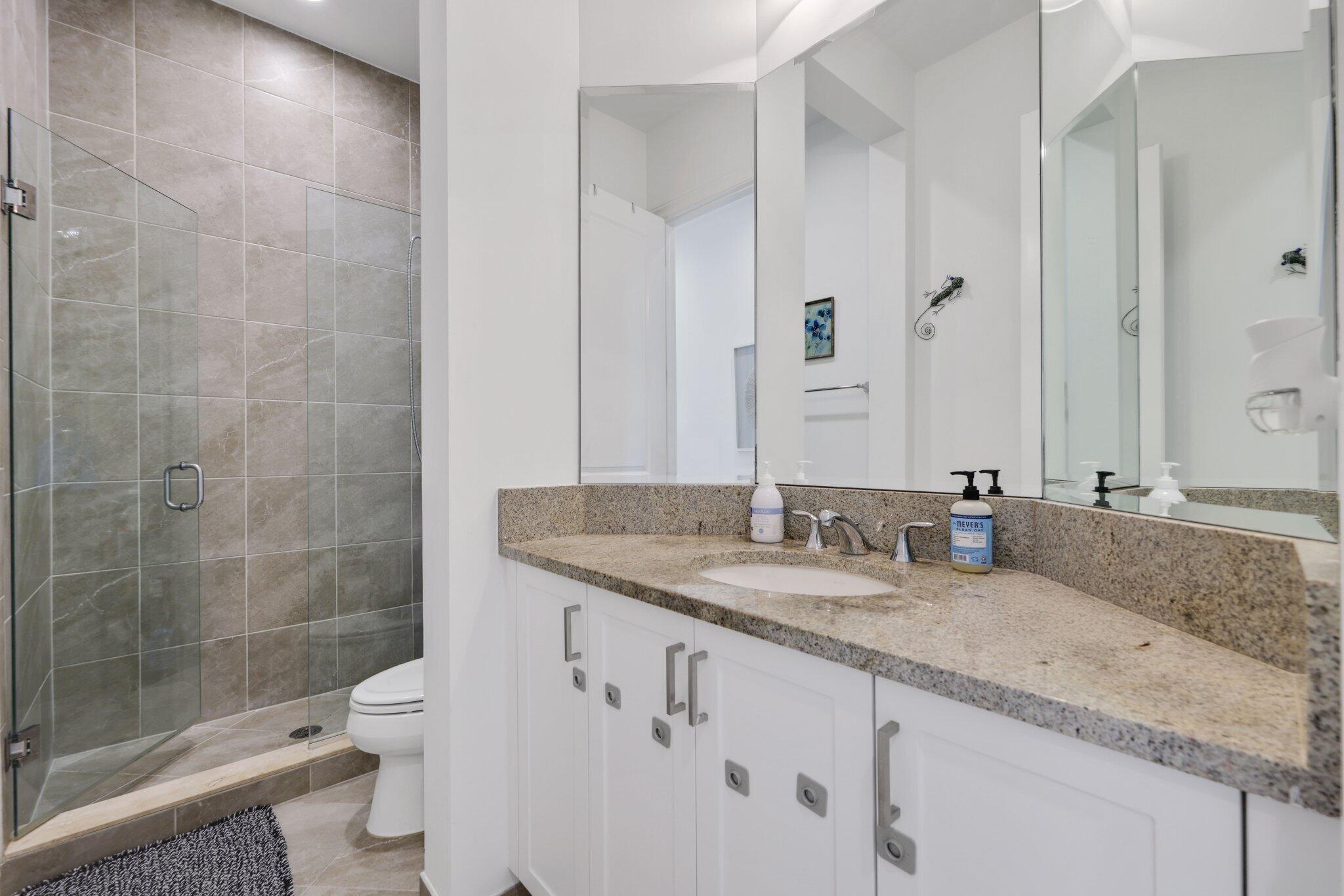 2751 Northwest 70th Boulevard Boca Raton, FL 33496 - Photo 54 of 76 a bathroom with a granite countertop sink a toilet and shower