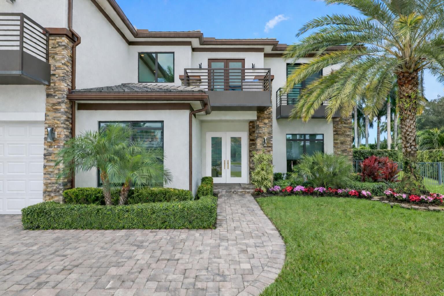 2751 Northwest 70th Boulevard Boca Raton, FL 33496 - Photo 6 of 76 a front view of a house with a garden and plants