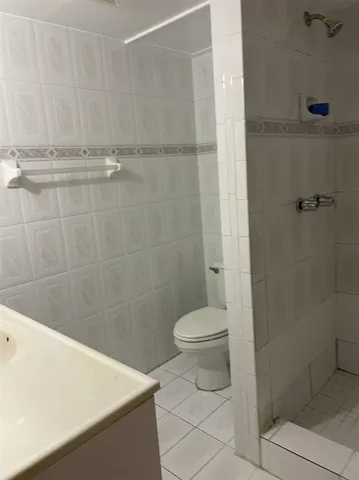 a bathroom with a toilet and a shower