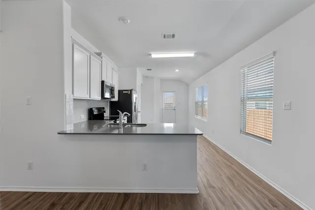 a kitchen with a sink cabinets stainless steel appliances and a window