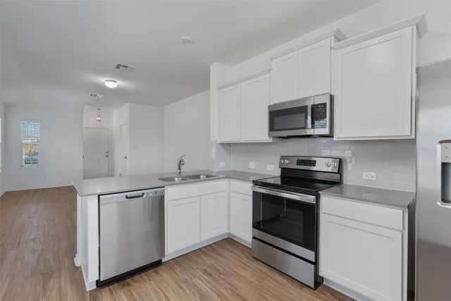 a kitchen with stainless steel appliances granite countertop a sink stove and microwave