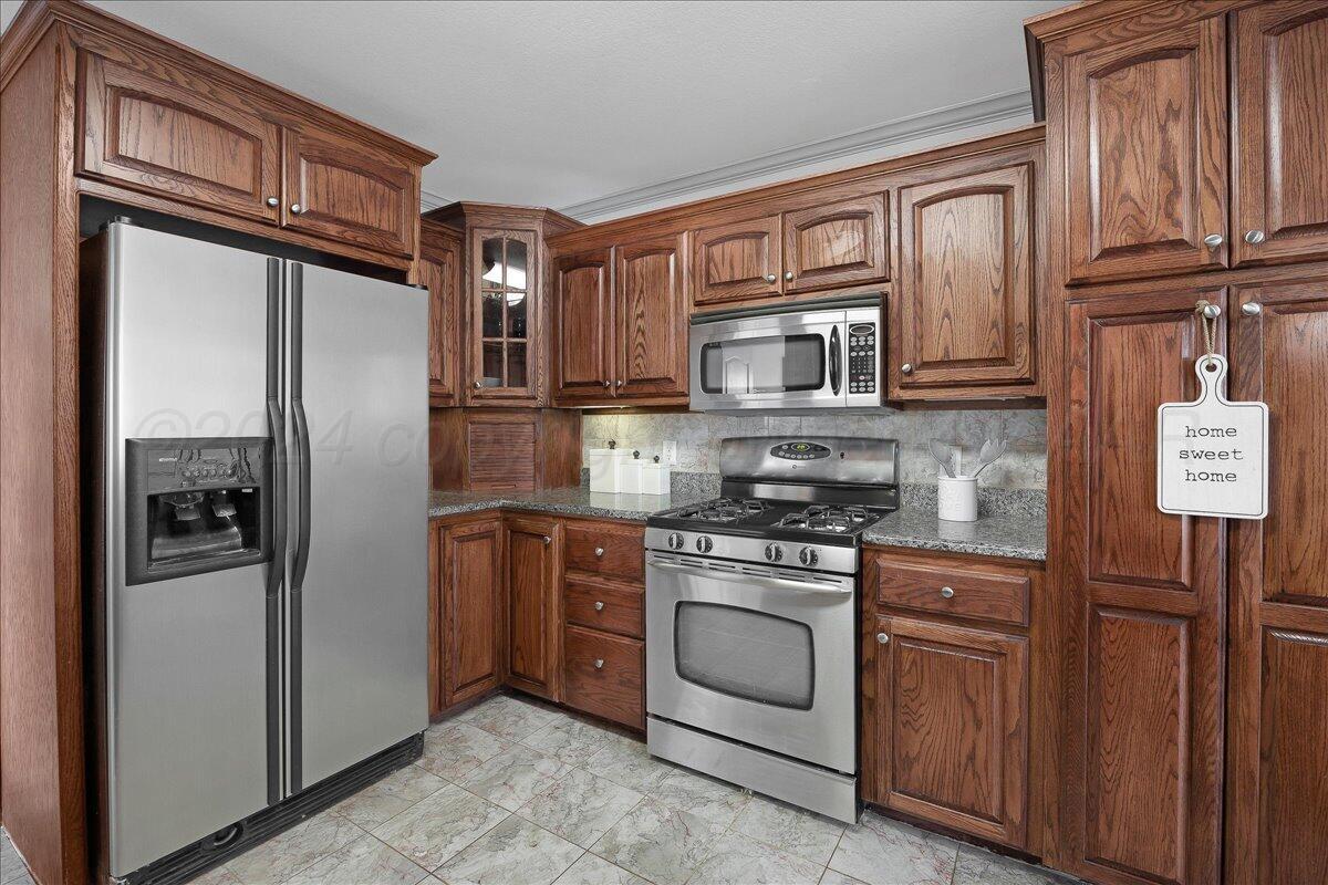 8501 Bryeson Lane Canyon, TX 79015 - Photo 12 of 25 a kitchen with stainless steel appliances granite countertop a refrigerator stove and oven