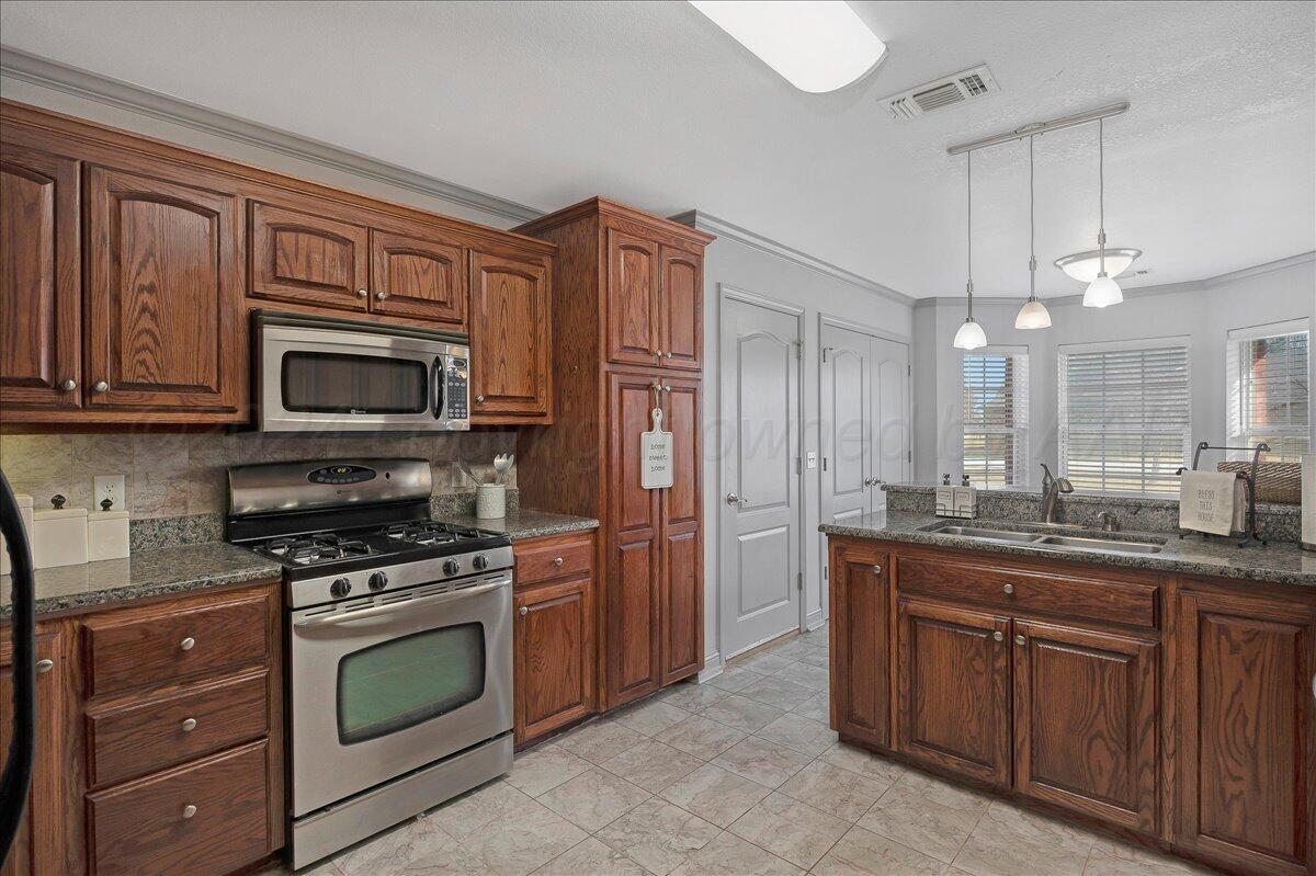 8501 Bryeson Lane Canyon, TX 79015 - Photo 10 of 25 a kitchen with stainless steel appliances granite countertop a stove and a microwave