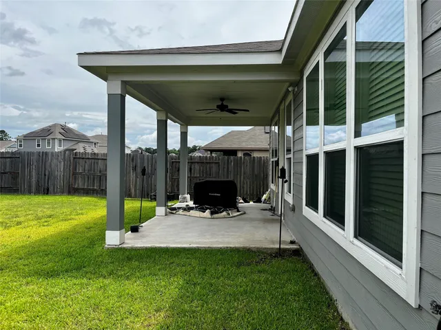 a view of a chair and table in backyard of the house